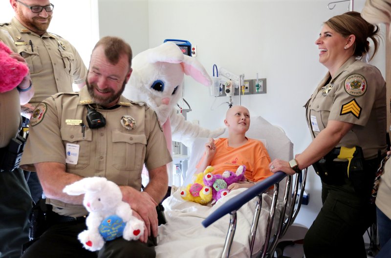 Marie Shillings, 13, tells a humorous story from her bed Wednesday, April 17, 2019, to members of the Benton County Sheriff's Office during the third annual Bunny Hop With A Cop at Arkansas Children's Northwest in Springdale. The office partnered with the Easter Bunny Foundation and are visiting three hospitals and one shelter in the area. NWA Democrat-Gazette/DAVID GOTTSCHALK