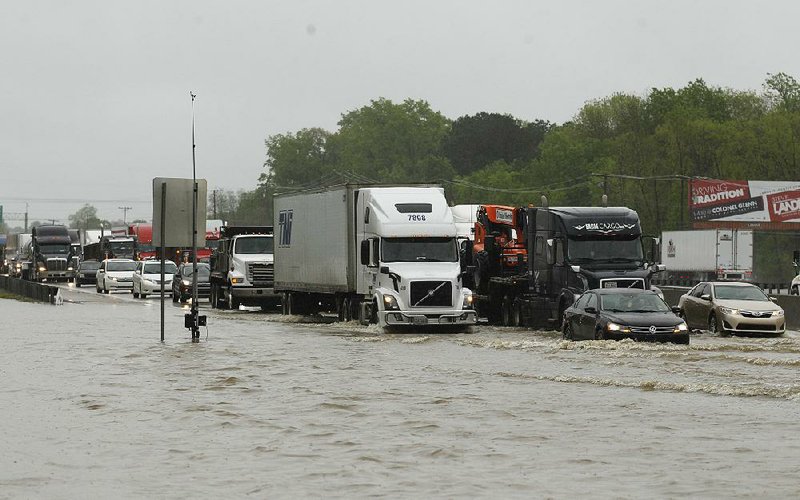 Cars and trucks creep through a flooded portion of Interstate 30, near mile marker 127 southwest of Little Rock on Thursday. More photos are available at www.arkansasonline.com/419flooding/ 