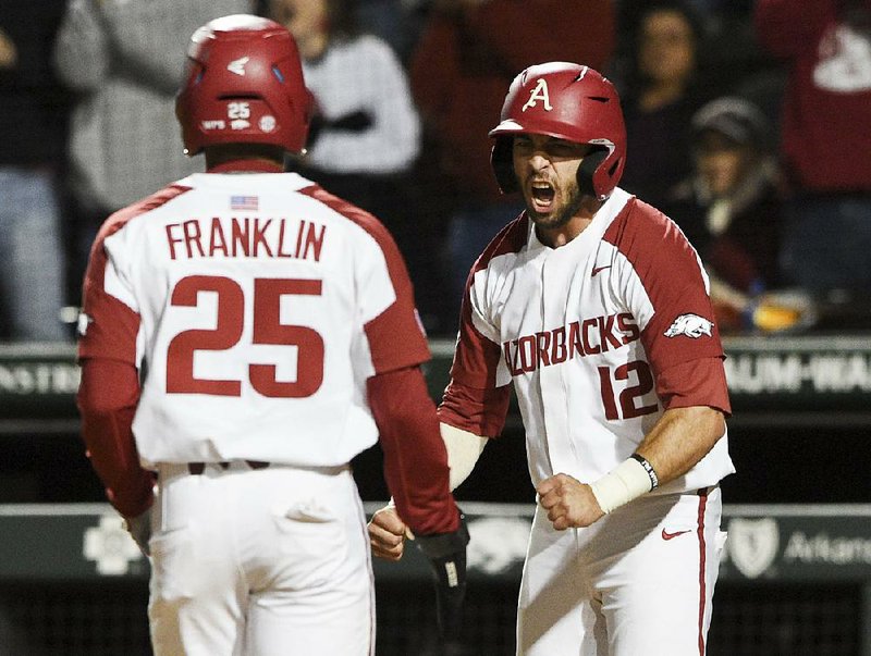 Arkansas’ Casey Opitz (right) celebrates with teammate Christian Franklin after both scored on a double by Casey Martin in the sixth inning of the No. 10 Razorbacks’ victory over No. 2 Mississippi State on Thursday night at Baum-Walker Stadium in Fayetteville.