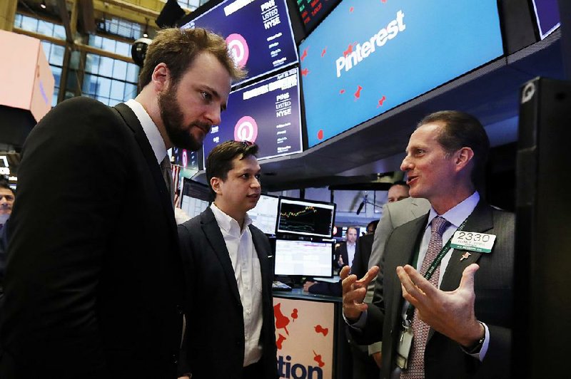 Pinterest Inc. execs Evan Sharp (from left) and Ben Silbermann talk Thursday with New York Stock Exchange specialist Glenn Carell on the trading floor before the company’s initial public offering. 