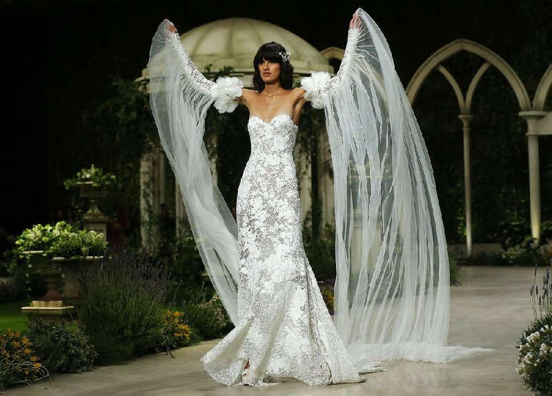 A model wears a creation from Pronovias in this file photo taken during the 2018 Barcelona Bridal fashion week in Barcelona, Spain. From dumping the bouquet and garter tosses to statement hats instead of veils, today’s brides and grooms are going their own way.