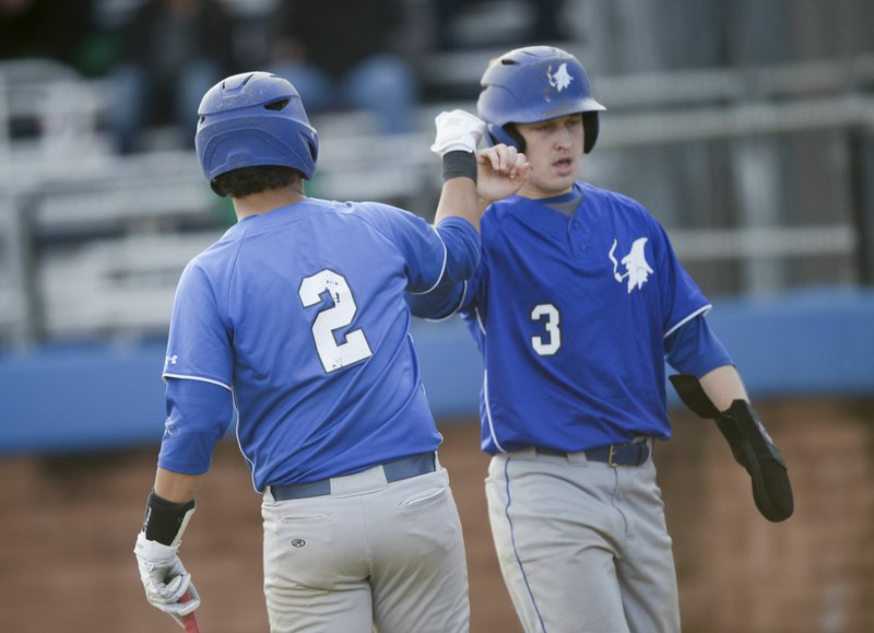 NWA Democrat-Gazette/CHARLIE KAIJO Rogers High teammate Sal Jacobo (2) and McKayden Templeton (3) first bump during a 6A-West Conference game earlier this season at Veterans Park in Rogers. Rogers has now on a seven-game winning streak and sits in second place in the league.