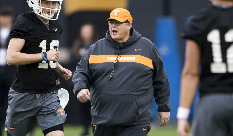 In this March 7, 2019, file photo, Tennessee offensive coordinator Jim Chaney walks on the field during Tennessee football's first practice of the spring season in Knoxville, Tenn. Chaney exemplifies the nomadic nature of an SEC coordinator. He's back for his second stint as Tennessee's offensive coordinator after holding the same title at Arkansas, Pittsburgh and Georgia since his last stay in Knoxville. (Caitie McMekin/Knoxville News Sentinel via AP, File)