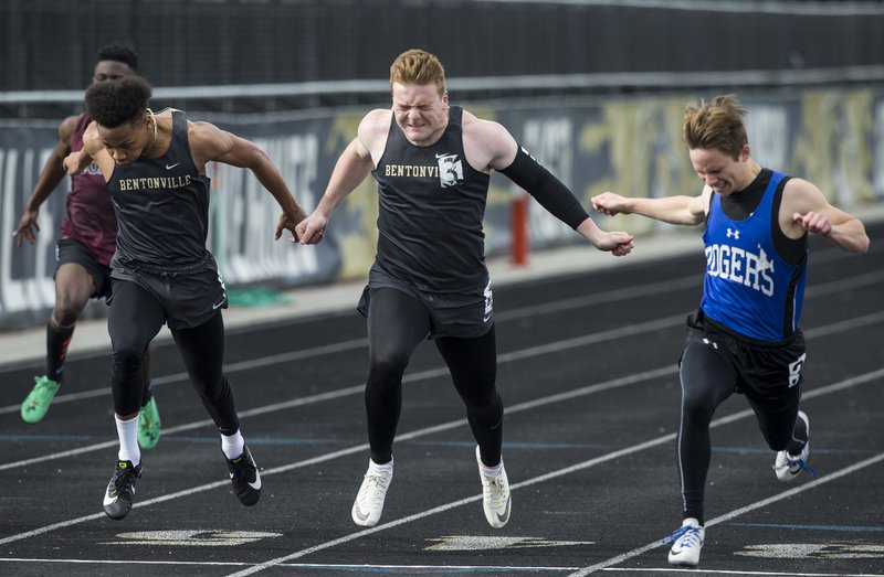 Colby Ried (from left) of Bentonville, Cole Joyce of Bentonville and Joshua Workman of Rogers cross the finish line in the 5th heat of the boys 100 meter dash Thursday, April 18, 2019, during the Wolverine Relays at Bentonville West in Centerton. Workman won with a time of 11.03 seconds with Joyce in second and Ried in third.
