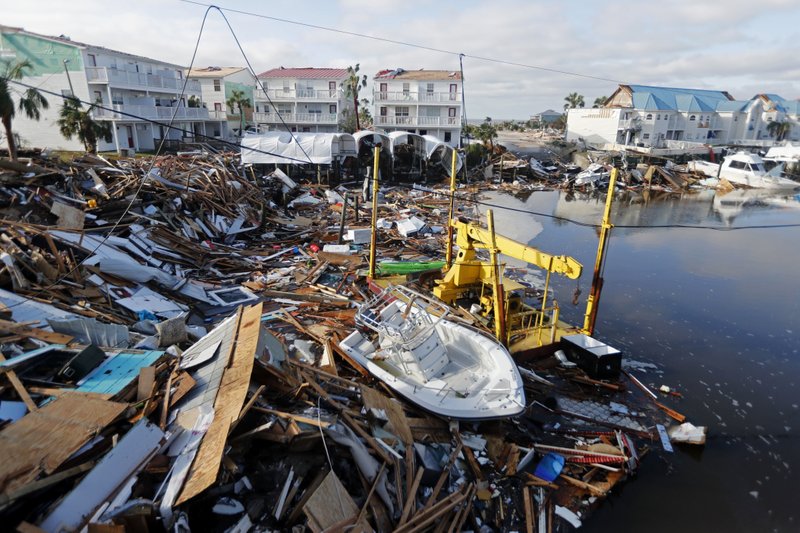 FILE - In this Oct. 11, 2018 file photo, a boat sits amidst debris in the aftermath of Hurricane Michael in Mexico Beach, Fla. Weather forecasters have posthumously upgraded last fall's Hurricane Michael from a Category 4 storm to a Category 5. The National Oceanic and Atmospheric Administration announced the storm's upgraded status Friday, making Michael only the fourth storm on record to have hit the U.S. as a Category 5 hurricane. (AP Photo/Gerald Herbert, File)
