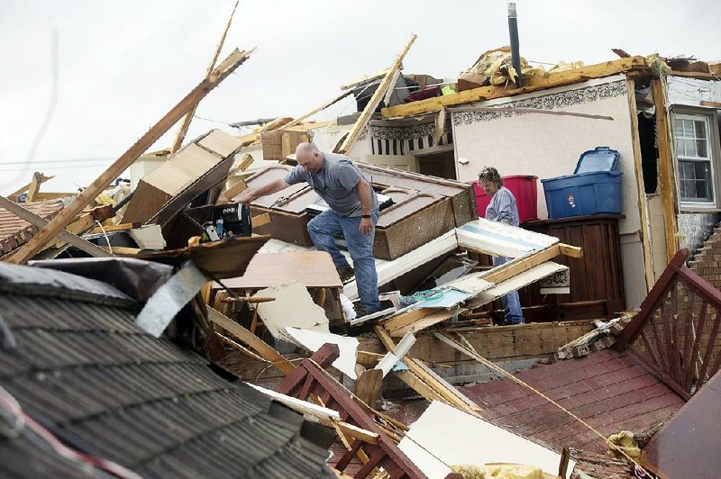 Friends and relatives help look through the wreckage of Delores Anderson’s house Friday in Franklin County, Va., after a possible tornado struck the area as a strong storm system swept through the South, causing widespread damage and at least four deaths. 