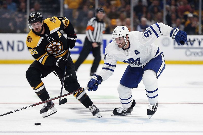 Toronto’s John Tavares (right) battles Boston’s David Krejci for the puck during the second period of Game 5 of an NHL first-round playoff series Friday in Boston. The Maple Leafs won 2-1 to take a 3-2 series lead. 