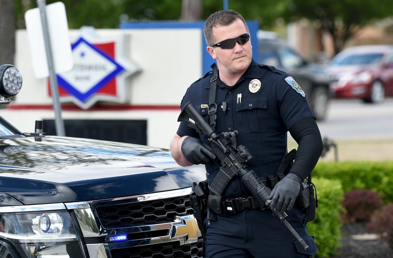 NWA Democrat-Gazette/DAVID GOTTSCHALK Officer Jason Cooper with the Fayetteville Police Department responds Friday to a bank robbery at the Centennial Bank, 3010 W. Martin Luther King Jr. Blvd. Sgt. Anthony Murphy, public information officer, said the suspect was described as a white man in his 20s, wearing a black jacket and blue pants with a blue stripe down the side, and a bandana across his face. The same bank was robbed Dec. 7, 2018