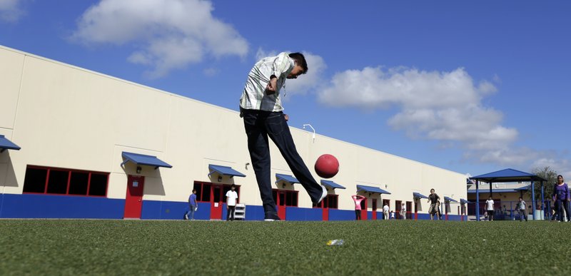 In this Sept. 10, 2014, file photo, detained immigrant children play kickball at the Karnes County Residential Center, a detention center for immigrant families, in Karnes City, Texas. The Trump administration stopped using the center to hold parents and children in March 2019. (AP Photo/Eric Gay, File)