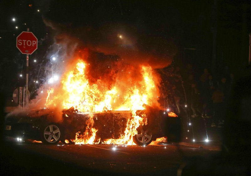 A car burns after petrol bombs were thrown at police in the Creggan area of Londonderry, in Northern Ireland, Thursday, April 18, 2019. (Niall Carson/PA via AP)