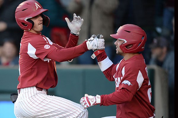 Arkansas shortstop Casey Martin (left) and outfielder Dominic Fletcher celebrate after Martin hit a grand slam during a game against Mississippi State on Friday, April 19, 2019, in Fayetteville. 