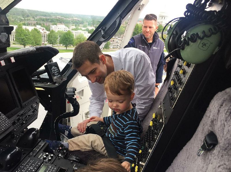 U.S. Sen. Tom Cotton lets his son Daniel sit in the cockpit of the Angel One helicopter on the roof of Arkansas Children’s Hospital in Little Rock during a visit Friday. His other son, Gabriel (head barely visible), tries out the left seat.