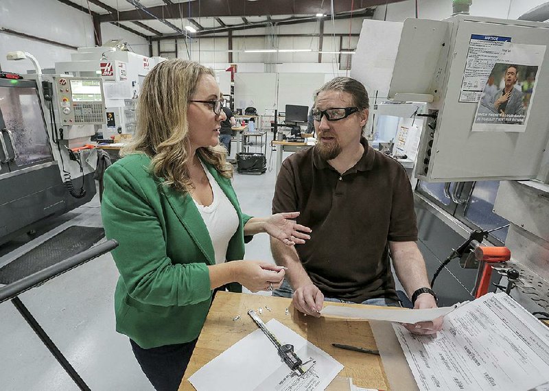 Gina Radke, chief executive officer of Galley Support Innovations in Sherwood (left) and engineer William Mauldin discuss the specifications for producing interior hardware for commercial and private aircraft on Thursday. 