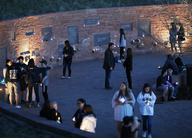 People walk through the Columbine Memorial during a vigil Friday night in Littleton, Colo.