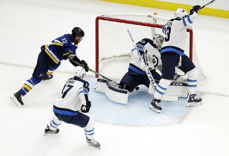 St. Louis’ Jaden Schwartz (left) scores past Winnipeg goaltender Connor Hellebuyck, and defenders Dustin Byfuglien (33) and Adam Lowry (17) during the first period of Game 6 of an NHL first-round playoff series Saturday in St. Louis. Schwartz scored all three goals for the Blues in the 3-2 victory, clinching the series 4-2.