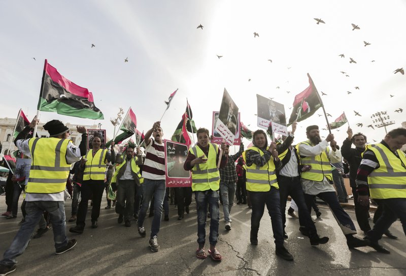 Protesters wear yellow vests at a protest in Tripoli, Libya as they chant slogans against Libya's Field Marshal Khalifa Hifter, who is leading an offensive to take over the capital of Tripoli, Friday, April 19, 2019. (AP Photo/Hazem Ahmed)