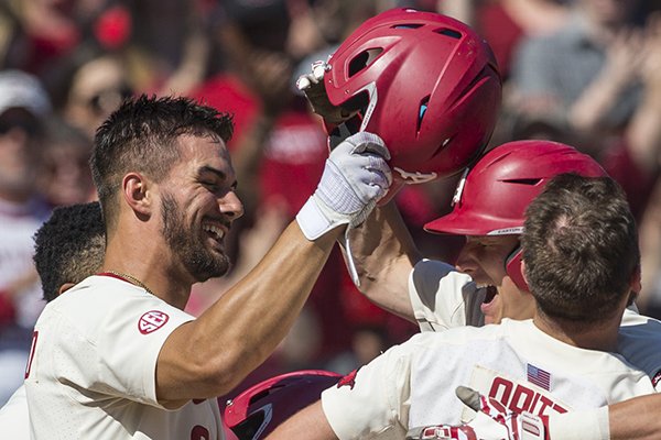 Arkansas' Jordan McFarland (left) congratulates teammate Jacob Nesbit (facing) after Nesbit hit a home run during the sixth inning of a game against Mississippi State on Saturday, April 20, 2019, in Fayetteville. The Razorbacks are in first place in the SEC West following a weekend sweep of the No. 2 Bulldogs, and one game back of the best record in the conference. 