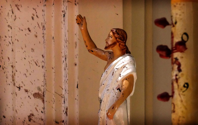 Blood stains are seen on the wall and on a Jesus Christ statue at the St. Sebastian's Church after blast in Negombo, north of Colombo, Sri Lanka, Sunday, April 21, 2019. More than two hundred people were killed and hundreds more injured in eight blasts that rocked churches and hotels in and just outside Sri Lanka's capital on Easter Sunday. (AP Photo)