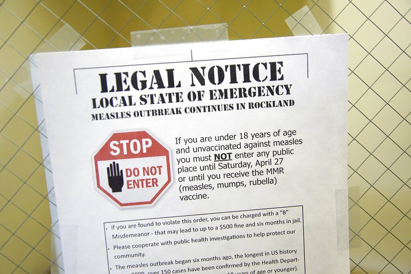 This March 27, 2019 file photo shows a sign explaining the local state of emergency because of a measles outbreak at the Rockland County Health Department in Pomona, N.Y. Outbreaks in New York state continue to drive up U.S. measles cases, which remain on pace to set a record for most illnesses in 25 years. (AP Photo/Seth Wenig, File)