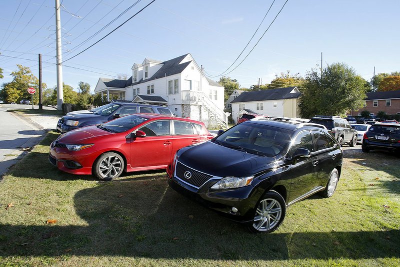 File photo/NWA Democrat-Gazette/DAVID GOTTSCHALK Vehicles are seen parked Oct. 22 behind 823 and 833 W. Stone Street at the intersection with Buchanan Avenue near Fayetteville High School. The Fayetteville Planning Commission last fall approved a permit for off-site parking at the private property through the end of the school year.