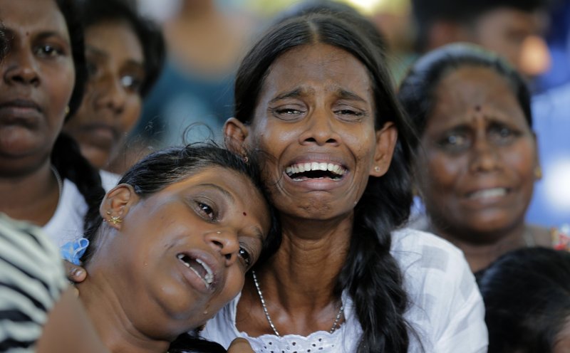 Relatives of the Burlington family weep during the funeral of their family members who were killed in the Easter Sunday bombings in Colombo, Sri Lanka, Tuesday, April 23, 2019. The six near-simultaneous attacks on three churches and three luxury hotels and three related blasts later Sunday were the South Asian island nation's deadliest violence in a decade while Sri Lanka police arrested 40 suspects in the wake of a state of emergency that took effect Tuesday giving the military war-time powers. (AP Photo/Eranga Jayawardena)