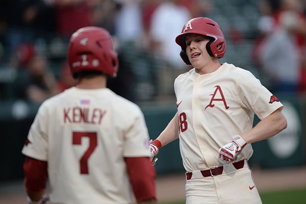 Arkansas right fielder Heston Kjerstad is congratulated at the plate Tuesday, April 23, 2019, by third baseman Jack Kenley after Kjerstad hit a solo home run during the third inning at Baum-Walker Stadium in Fayetteville. 