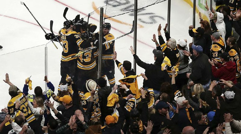 Boston fans celebrate as players gather to congratulate center Sean Kuraly on his third-period goal Tuesday as the Bruins defeated the Toronto Maple Leafs 5-1 in Game 7 of their NHL Eastern Conference playoff series in Boston. 