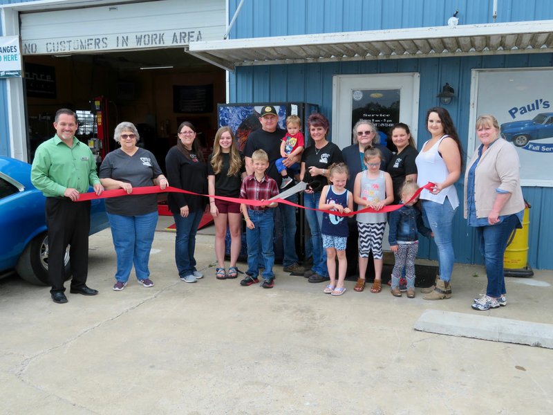 Westside Eagle Observer/RANDY MOLL Paul Wade and Sheila Holt (center) cut the ribbon on Paul's Place Wednesday afternoon. They were accompanied by Gentry Mayor Kevin Johnston, Jackie Bader, Brandy Cordeiro, Shelby Wade, Jesse Berner, Emmitt Taylor, Linda Holt, Peyton Hendren, Amanda Hendren, Bailey Hendren, Esperanza Martinez, Lilly Grace Hendren and Gentry Chamber of Commerce director Janie Parks.