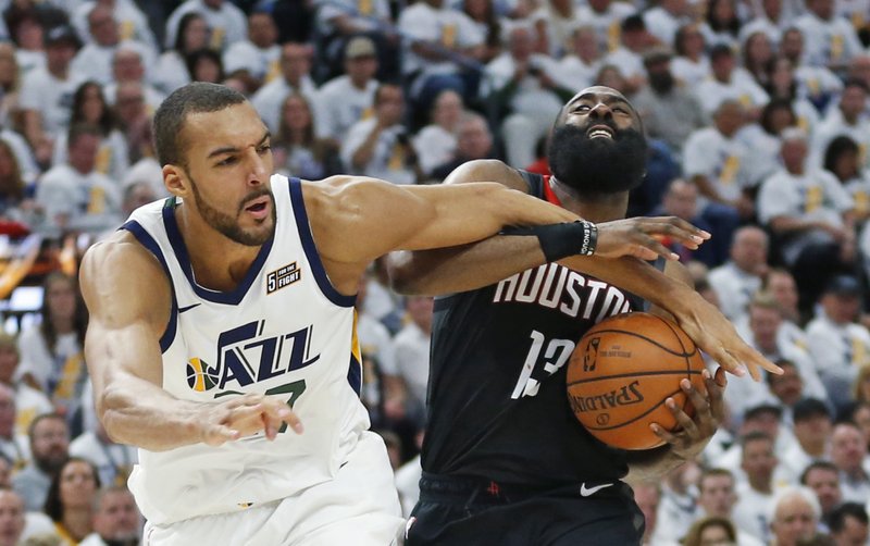 Utah Jazz center Rudy Gobert, left, fouls Houston Rockets guard James Harden (13) as he drives to the basket in the first half during Game 4 of a first-round NBA basketball playoff series, Monday, April 22, 2019, in Salt Lake City. (AP Photo/Rick Bowmer)