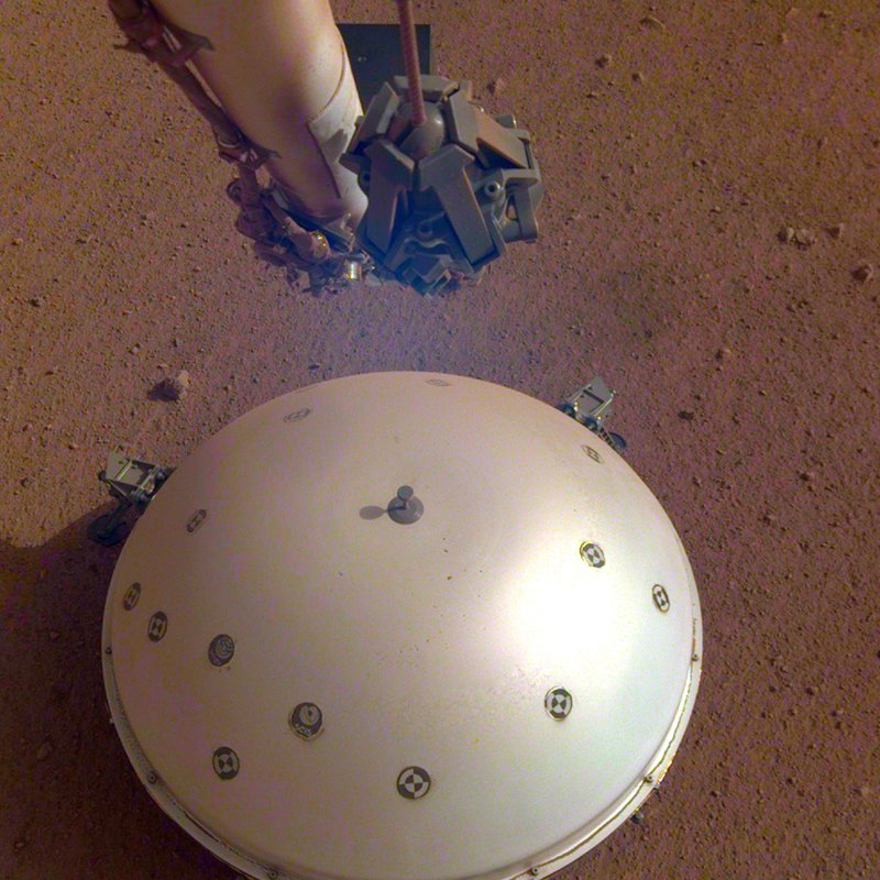 This photo made available by NASA on Tuesday, April 23, 2019 shows the InSight lander's domed wind and thermal shield which covers a seismometer on the 110th Martian day, or sol, of the mission. On Tuesday, the space agency announced the instrument picked up a gentle rumble, believed to be the first marsquake ever detected. (NASA/JPL-Caltech via AP)