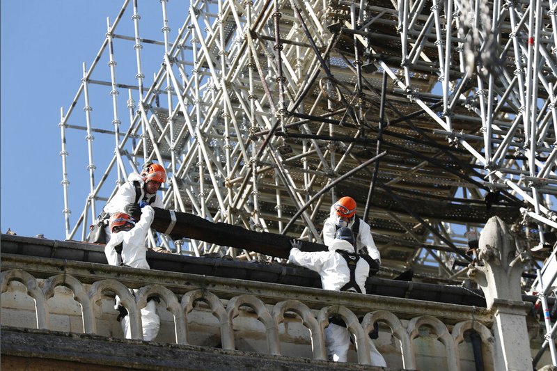 Workers install protections on Notre Dame cathedral Wednesday, April 24, 2019 in Paris. Professional mountain climbers were hired to install synthetic, waterproof tarps over the gutted, exposed exterior of Notre Dame Cathedral, as authorities raced to prevent further damage ahead of storms that are rolling in toward Paris. (AP Photo/Thibault Camus)
