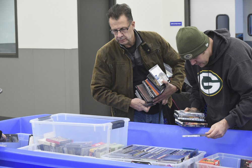 In this April 12, 2019, photo Ron Edquist, left, of Kenosha, peruses a bin full of DVDs, video games and Blu-ray Discs at the Goodwill outlet store in Sturtevant, Wis. (Adam Rogan/The Journal Times via AP)