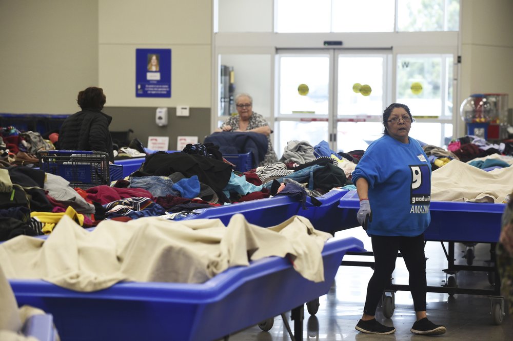 In this April 12, 2019, photo a employee lines up bulk bins full of unsold products to be unveiled at Goodwill's outlet store in Sturtevant, Wis. (Adam Rogan/The Journal Times via AP)