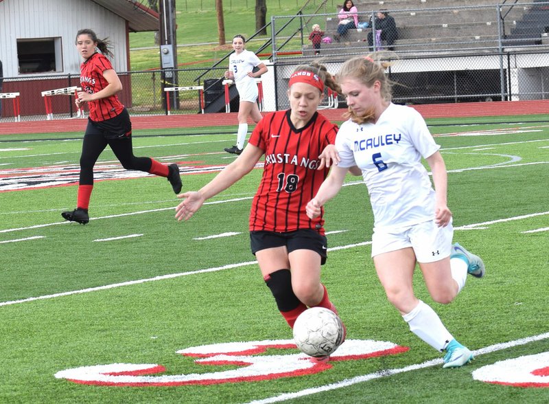 RICK PECK/SPECIAL TO MCDONALD COUNTY PRESS McDonald County's Ava Smith passes the ball forward during the Lady Mustangs' 1-0 loss to Joplin McAuley on April 18 at MCHS.