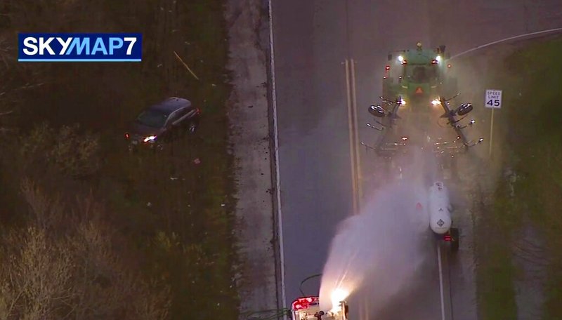 In this image made from video provided by ABC7 Chicago, a fire engine sprays water on a container of a chemical that farmers use for soil after anhydrous ammonia leaked Thursday, April 25, 2019, in Beach Park, Ill. Authorities say dozens of people have been taken to hospitals after anhydrous ammonia leaked from containers that a tractor was pulling in a Chicago suburb. (ABC7 Chicago via AP)