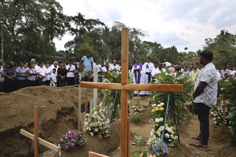 A priest conducts funeral service for a victim of Easter Sunday's bomb blast at St. Sebastian Church, in Negombo, Sri Lanka Thursday, April 25, 2019. The U.S. Embassy in Sri Lanka warned Thursday that places of worship could be targeted for militant attacks over the coming weekend, as police searched for more suspects in the Islamic State-claimed Easter suicide bombings that killed over 350 people. (AP Photo/Manish Swarup)