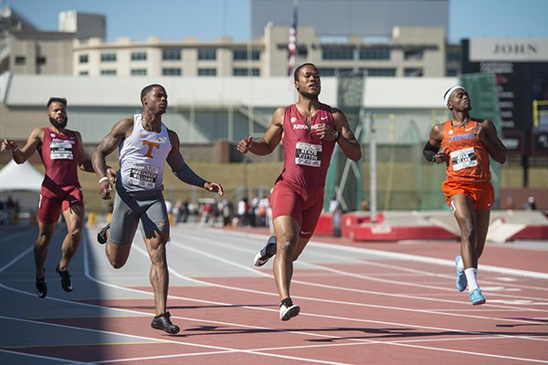 Roy Ejiakuekwu (from left) of Arkansas, Mustaqeem Williams of Tennessee, Kenzo Cotton of Arkansas and Ryan Clark of Florida run through the finish in the final heat of the men's 100-meter dash Friday, April 27, 2018, during the National Relay Championships at John McDonnell Field in Fayetteville.
