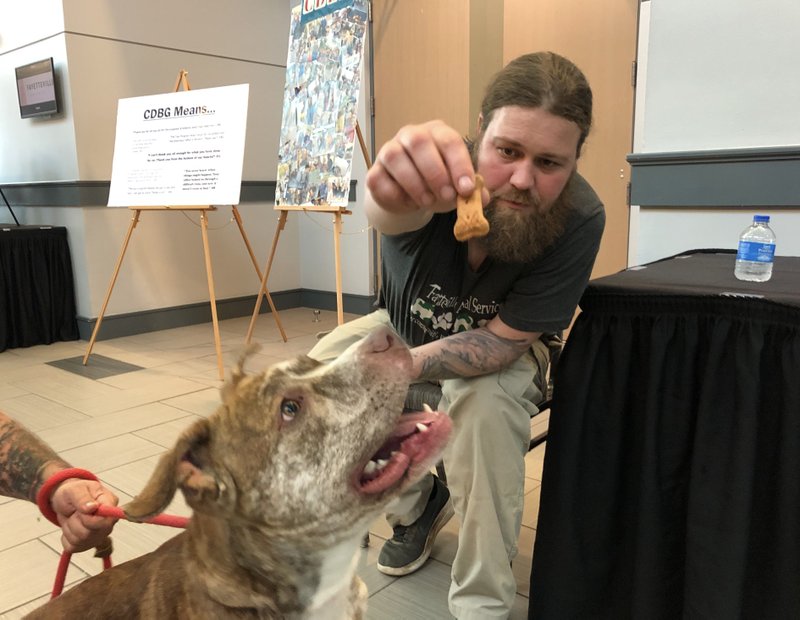 NWA Democrat-Gazette/STACY RYBURN

Randon Hassell with Fayetteville Animal Services gives Zuzu, a 2-year-old pit bull mix, a treat during the city’s annual Progress in Print event at the Town Center. The event highlights the impact of Community Development Block Grant programs, which range from housing and case management to pet food for low-income households.