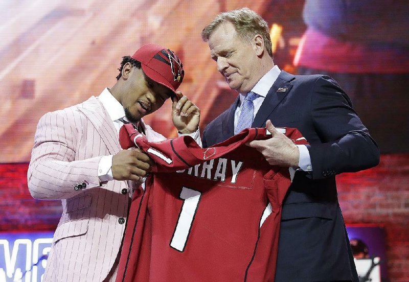 Kyler Murray (left) is presented an Arizona Cardinals jersey and hat by NFL Commissioner Roger Goodell on Thursday night in Nashville, Tenn. Murray, the Heisman Trophy winner last season, was selected with the first pick of the NFL Draft by the Cardinals.