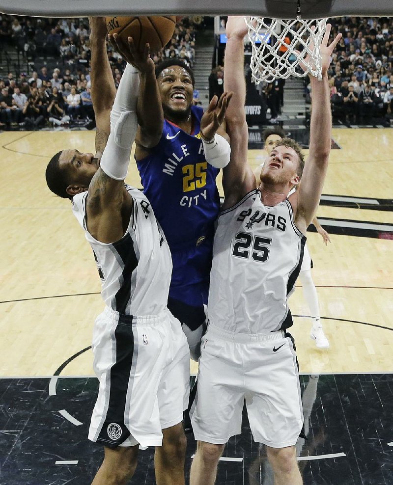 Denver Nuggets guard Malik Beasley (center) puts up a shot between LaMarcus Aldridge (left) and Jakob Poeltl of the San Antonio Spurs in Game 6 of their NBA playoff series Thursday.