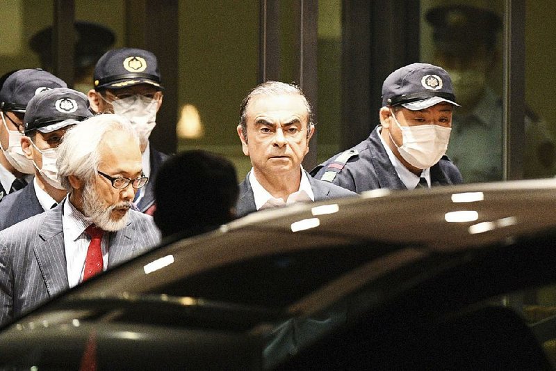 Former Nissan Chairman Carlos Ghosn (center) leaves a Tokyo jail Thursday. He has been detained twice since November. 