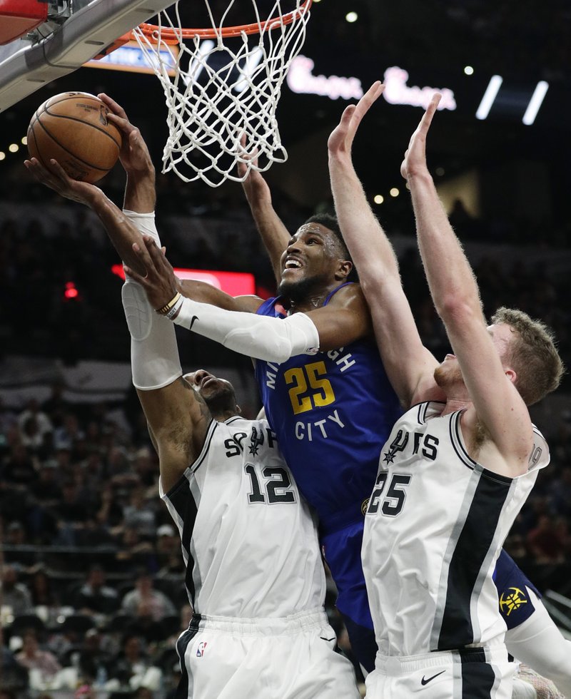 The Associated Press BATTLE FOR THE BALL: Denver Nuggets guard Malik Beasley (25) drives to the basket between San Antonio Spurs center LaMarcus Aldridge (12) and center Jakob Poeltl (25) during the first half of Thursday's playoff game in San Antonio.
