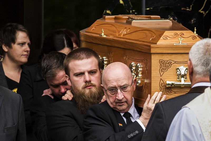 Sara Canning, partner of Lyra McKee, walks behind her coffin as it is carried out of St Anne's Cathedral in Belfast, northern Ireland, Wednesday April 24, 2019. The leaders of Britain and Ireland will join hundreds of mourners Wednesday at the funeral of Lyra McKee, the young journalist shot dead during rioting in Northern Ireland last week. (Liam McBurney/PA via AP)