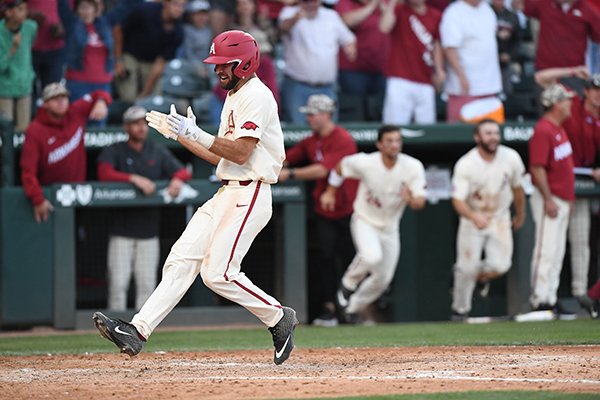 Arkansas second baseman Jack Kenley crosses home plate to score the winning run during the Razorbacks' 4-3 win over Tennessee on Sunday, April 28, 2019, in Fayetteville. 