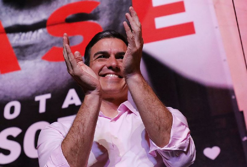 Spanish Prime Minister Pedro Sanchez, the Socialist party leader, applauds Sunday after speaking to supporters outside party headquarters in Madrid. 