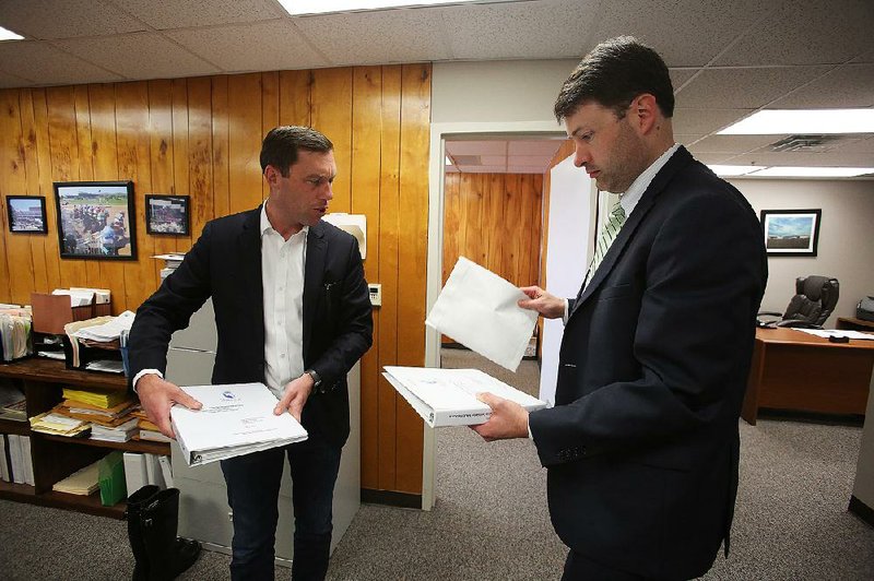 Quapaw Nation attorneys Nate Steel (left) and Alex Gray give a final look to the tribe’s application for a casino license Wednesday at the Arkansas Racing Commission offices in Little Rock. 