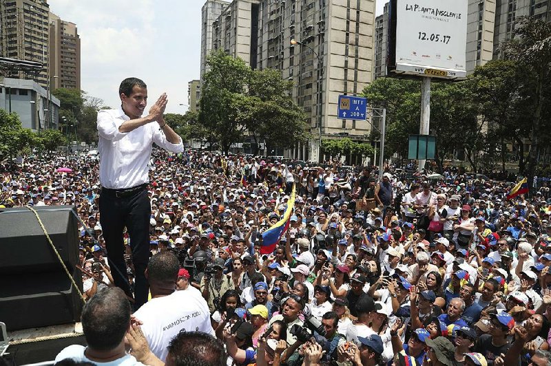 Venezuela opposition leader Juan Guaido addresses thousands of supporters Wednesday in Caracas. “Let’s keep up the pressure in the streets,” he told them. “The end is around the corner!” 