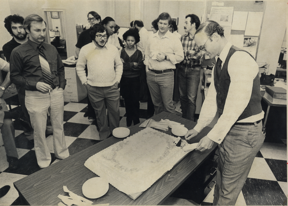 Walter Hussman, far right, cuts a cake on Nov. 1, 1980, as newsroom employees look on. (Arkansas Democrat-Gazette file photo)