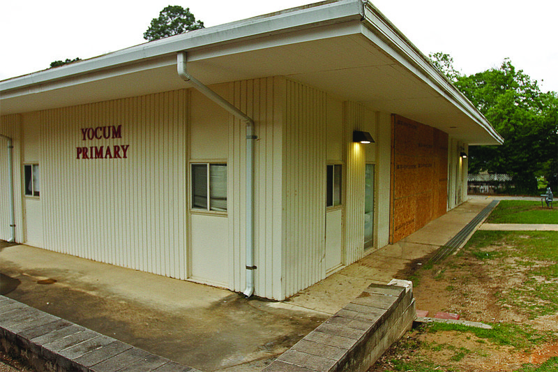 Damage: Large sheets of plywood cover damage to the north face of Yocum Primary School after a motorist collided with the building early Friday morning.  Terrance Armstard/News-Times