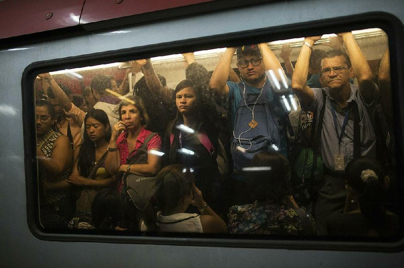 Venezuelans crowd a train on their morning commute Friday in Caracas where streets were calm, but opposition leader Juan Guaido called for protesters to gather today outside military bases.